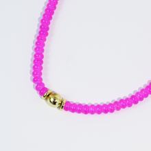 Load image into Gallery viewer, Necklace with pink beads and a gold clasp on a light purple background