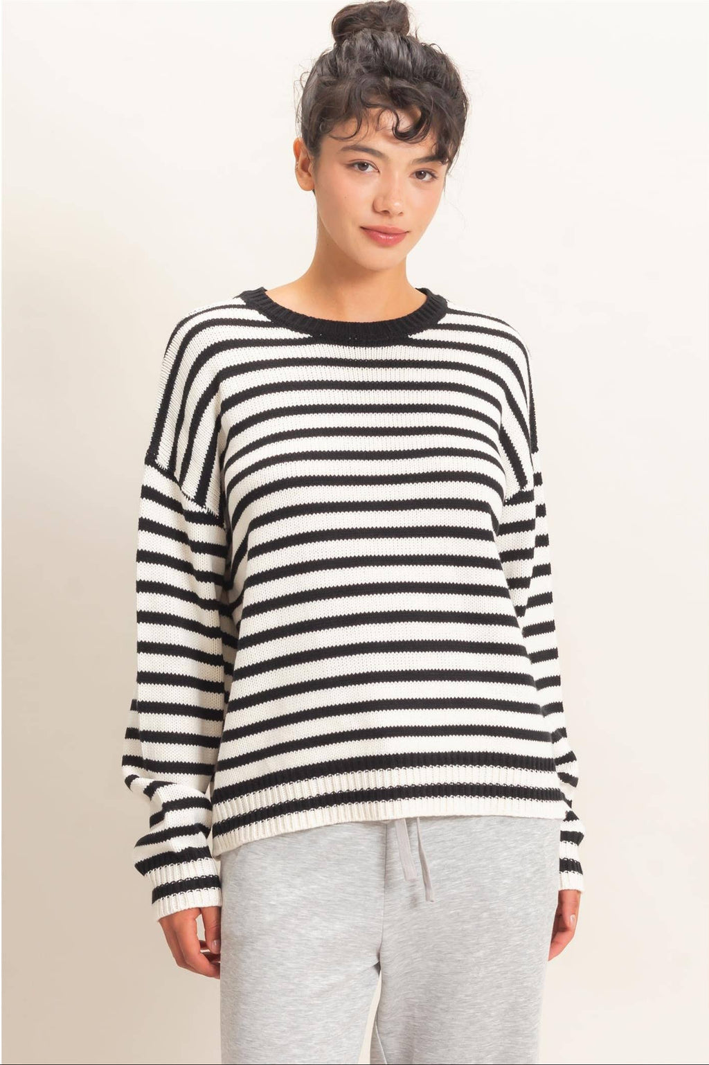 Women's black and white striped knit sweater with crew neckline, relaxed fit, and long sleeves.