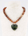 Brown beaded necklace with green stone heart pendant.