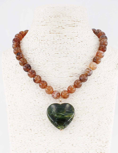 Brown beaded necklace with green stone heart pendant.