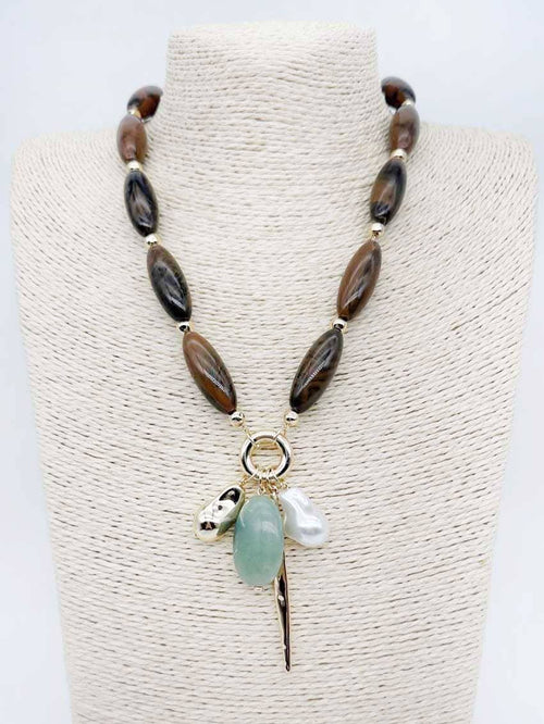 Brown natural stone necklace with pearl and green stone charms.