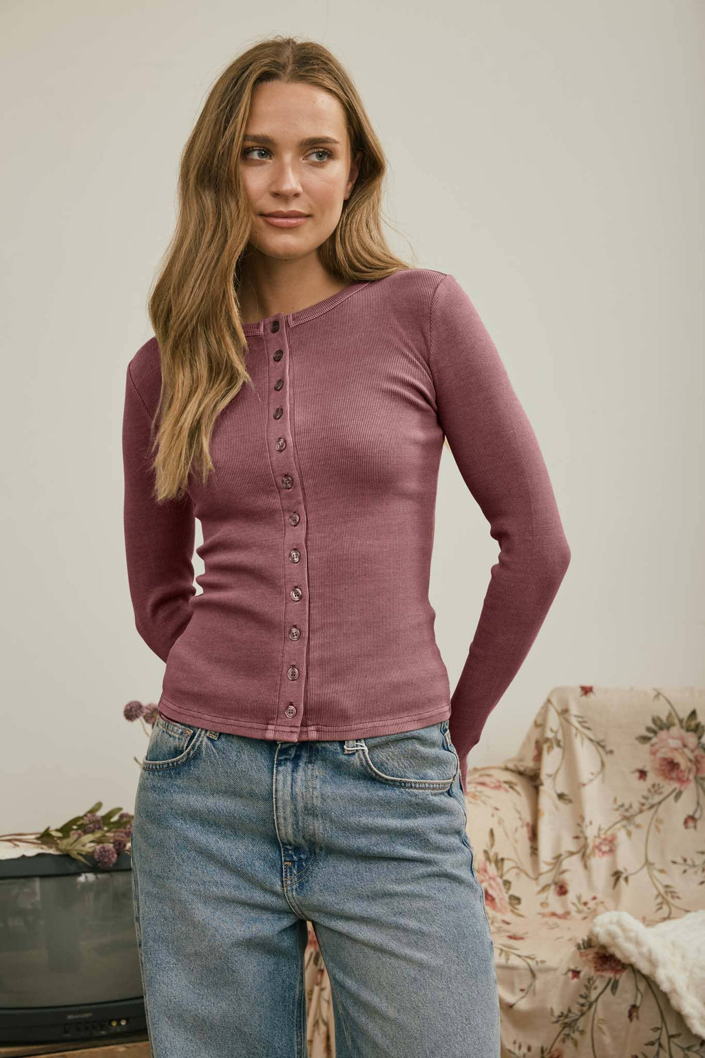Button front round neck knit top with fitted silhouette and long sleeves.