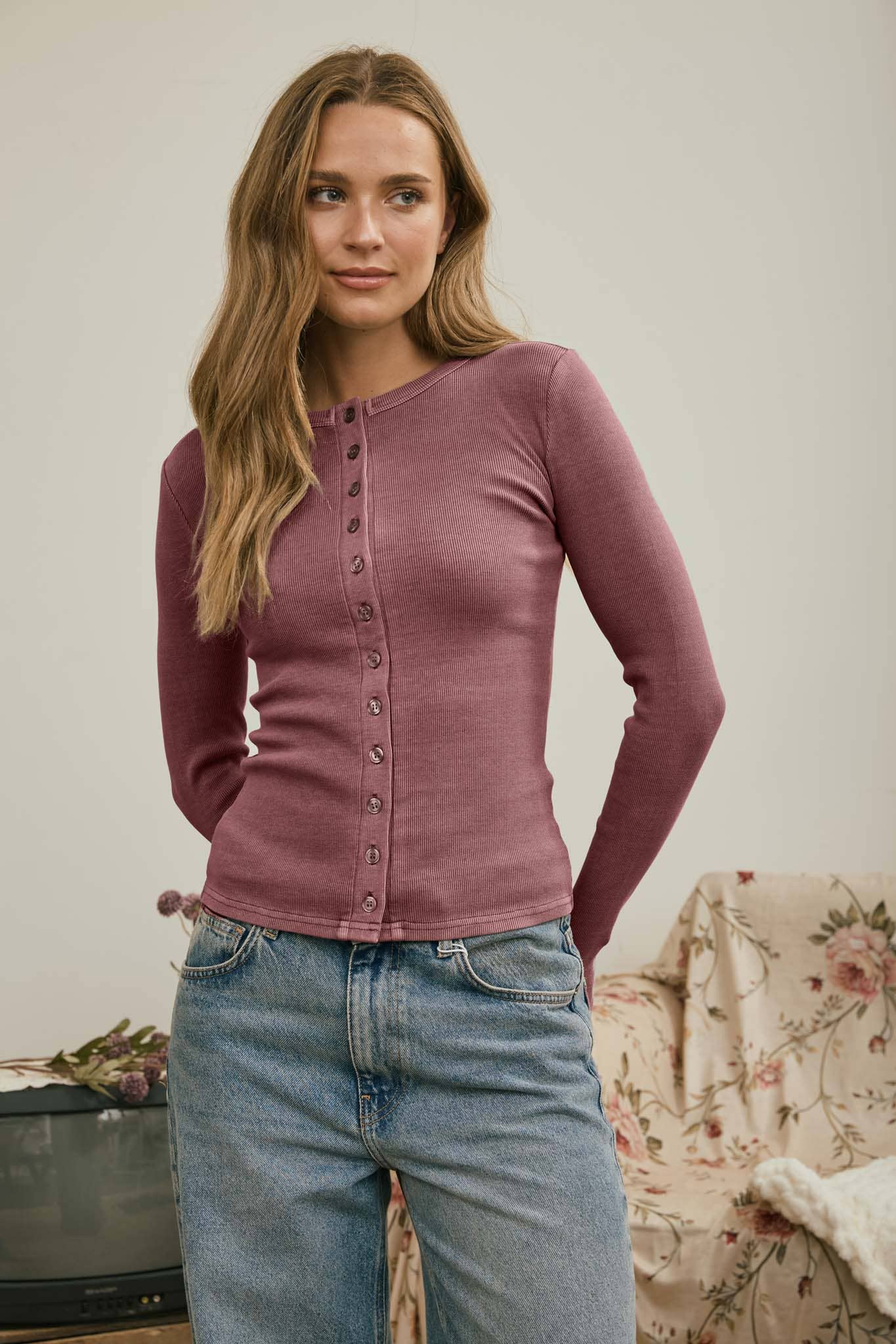 Button front round neck knit top with fitted silhouette and long sleeves.