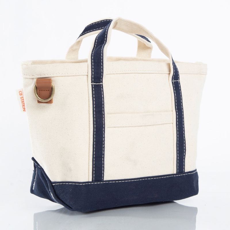 A canvas tote bag in off-white and navy blue with white contrast stitching.