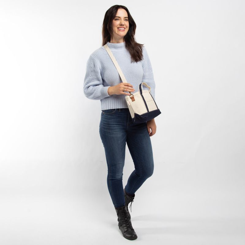 Woman holding a crossbody bag against a white background