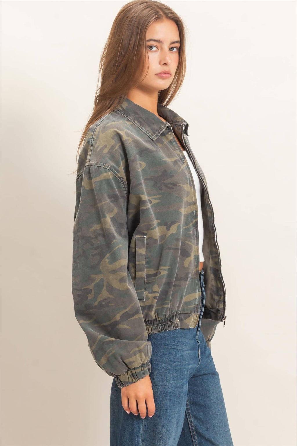 Side view of women's camo jacket featuring elastic cuffs, elastic hem, and relaxed fit.