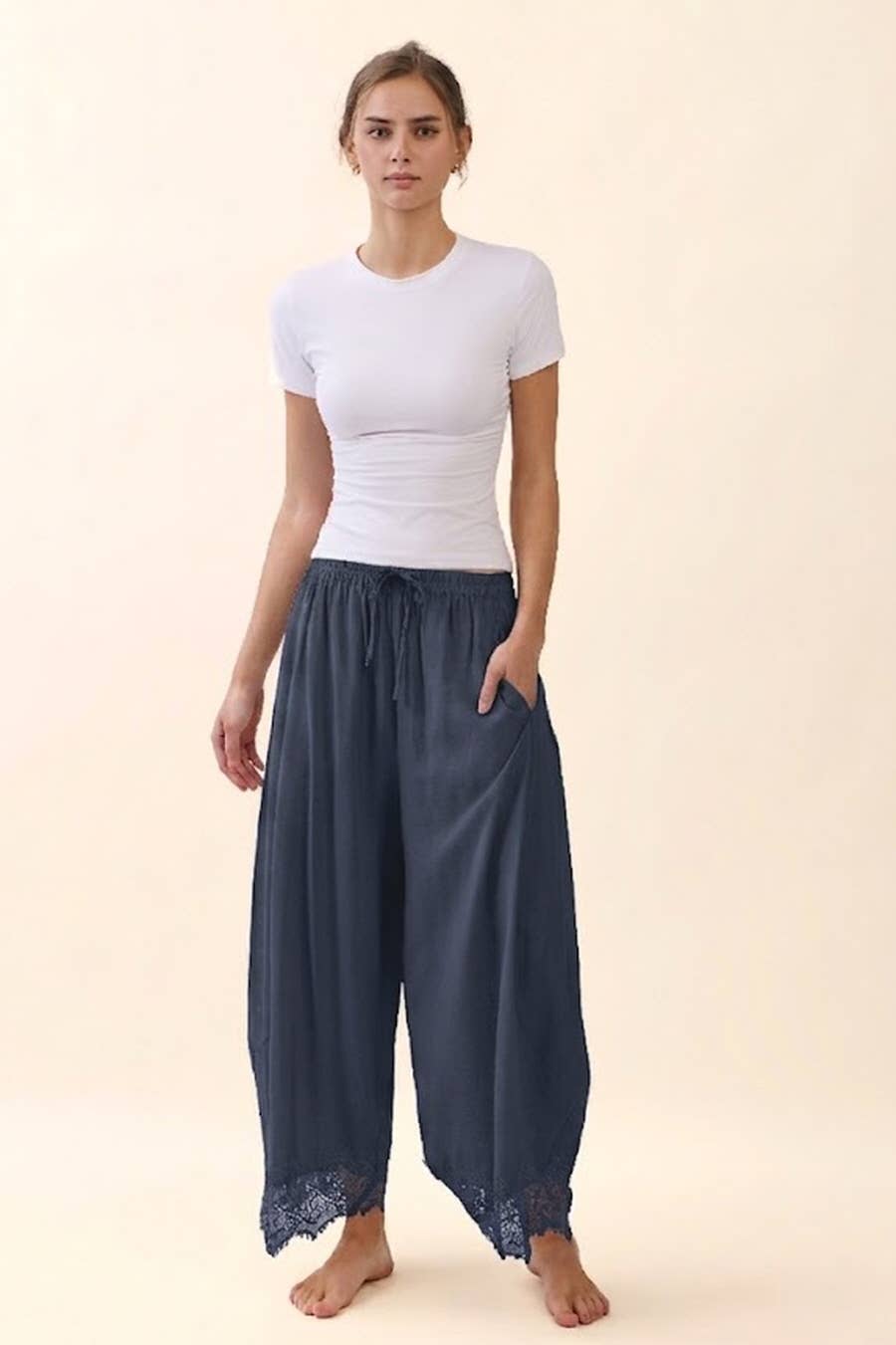 Women's crinkled wide leg pants with elastic waistband, side pockets, and lace hem detail in charcoal blue.