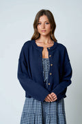 Women's navy button down knit cardigan with raw edge trim, crew neckline, and relaxed fit.