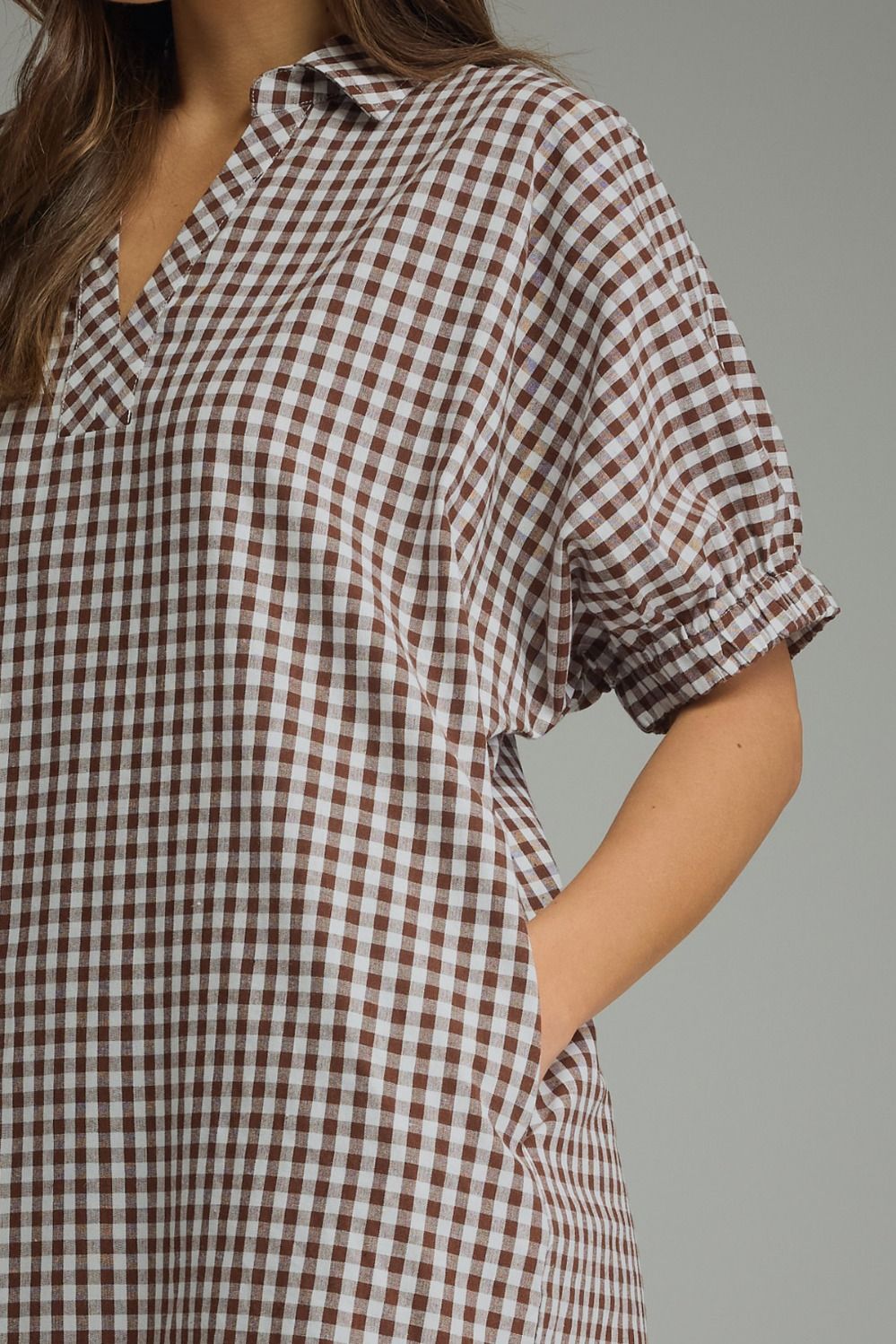 Close-up of the gathered short puff sleeves on the gingham midi dress.