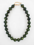 A necklace made of faceted dark green beads with natural marbling, featuring a gold-tone lobster clasp closure, shown on a plain white background.