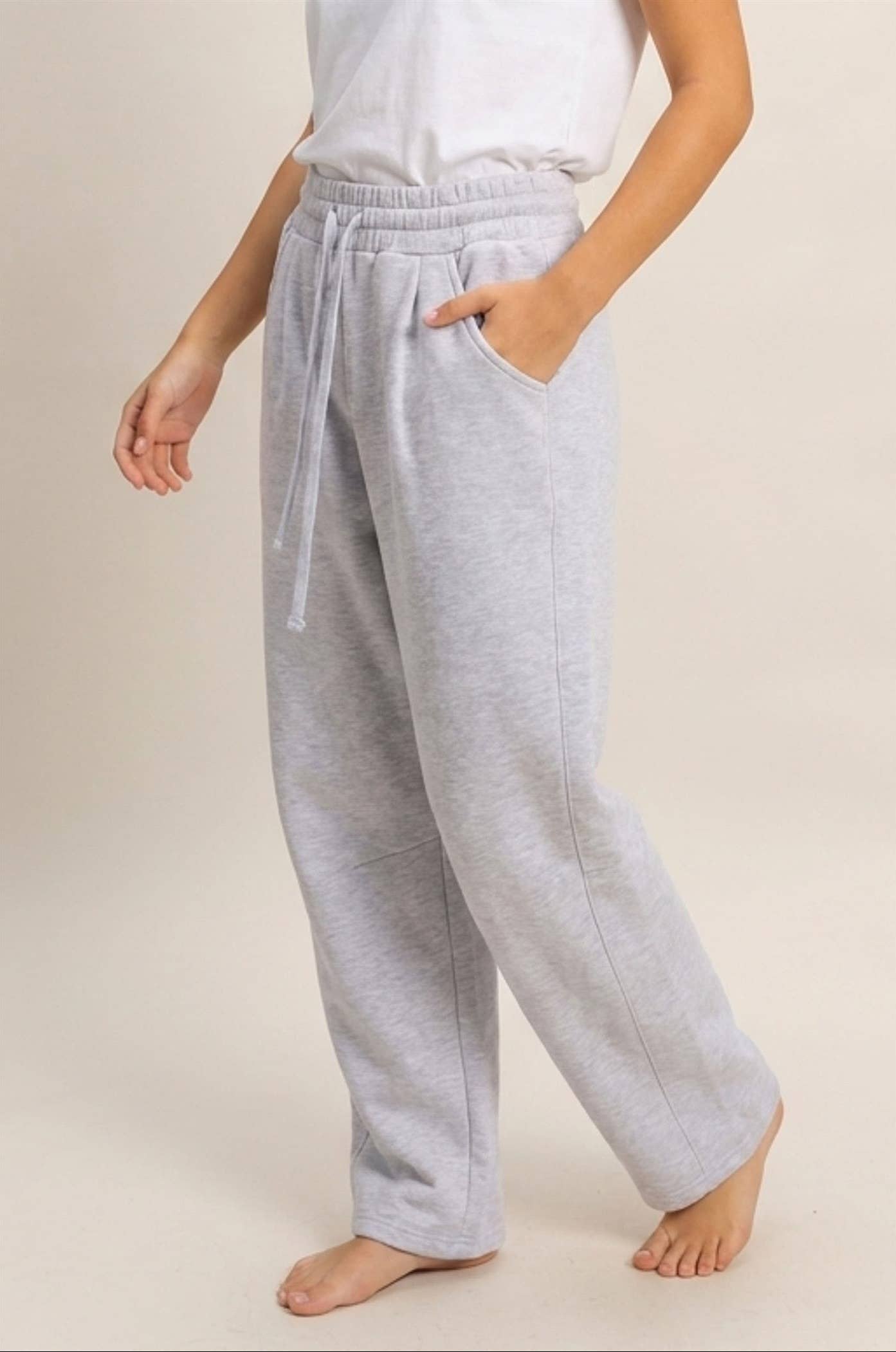 Side view of women's heather gray barrel leg sweatpants featuring roomy side pockets and elastic drawstring waistband
