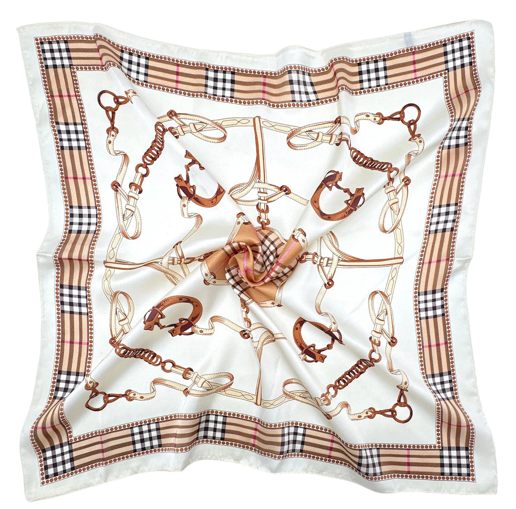 A square silk scarf featuring an equestrian theme with horse bits and reins printed in brown and gold on a white background, finished with a beige and black check border.