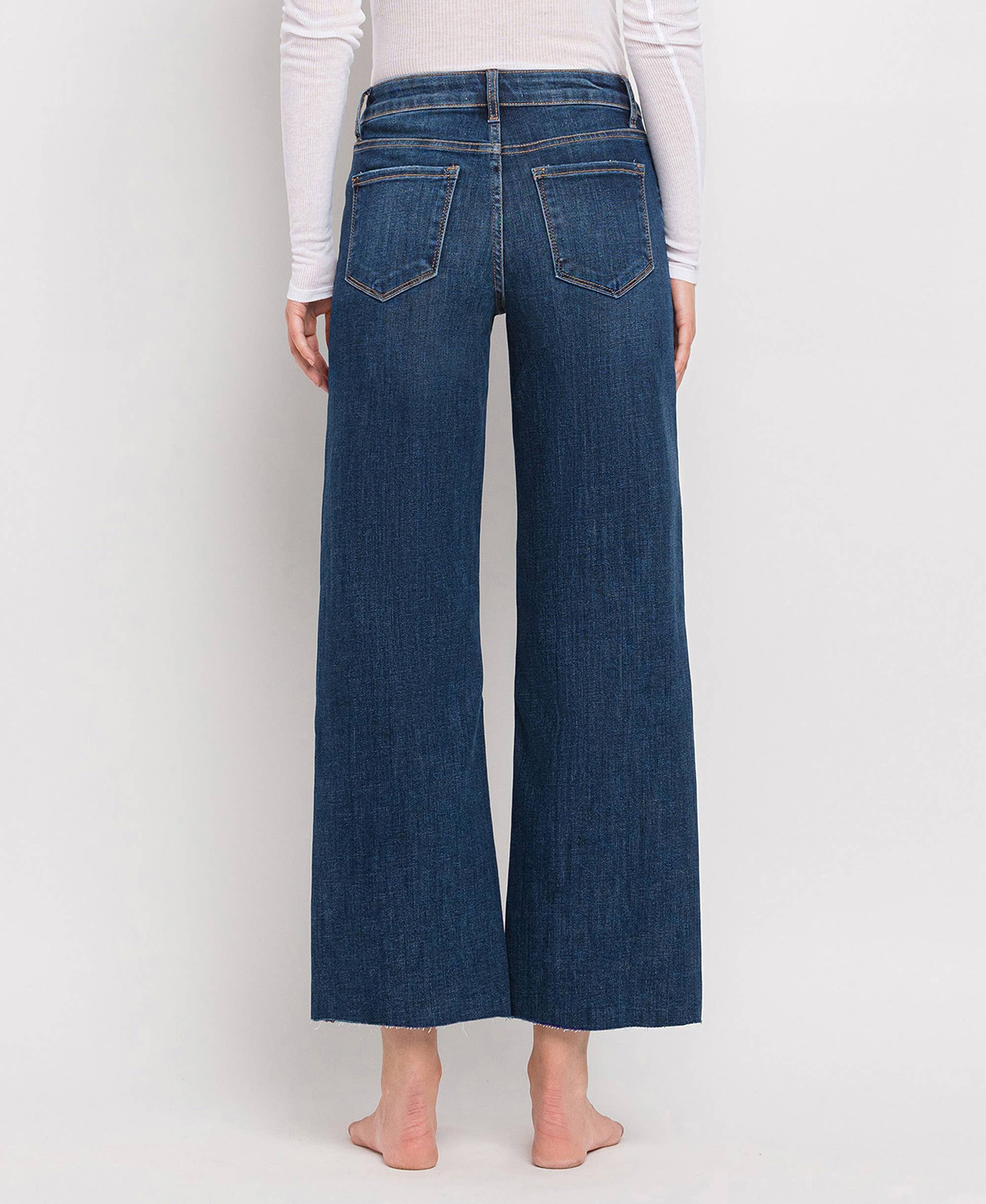 Back view of women's dark wash wide leg jeans with a flattering mid-rise fit and five-pocket design.