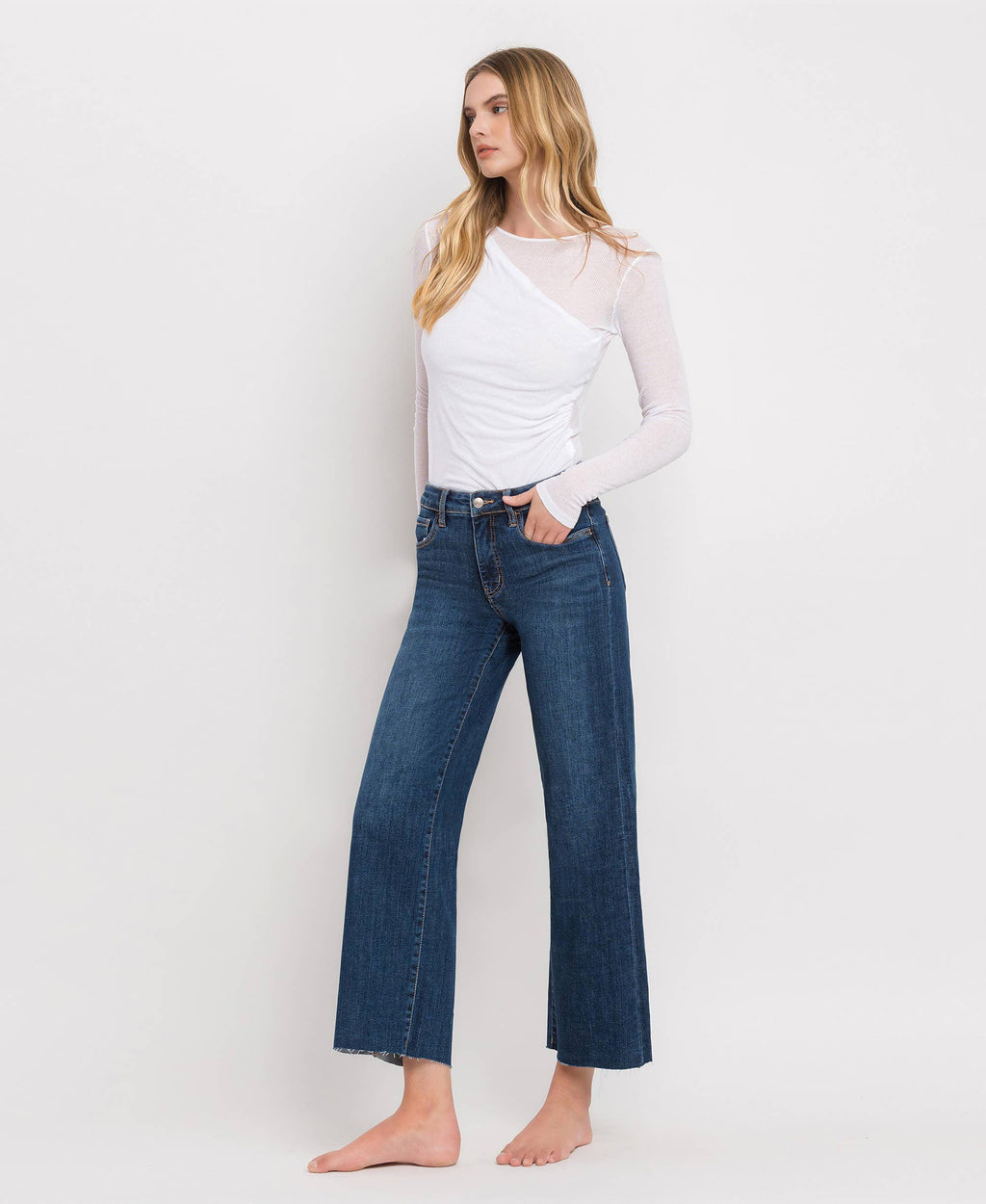 Side profile of cropped wide leg jeans made from comfort stretch denim with a clean-cut raw hem.