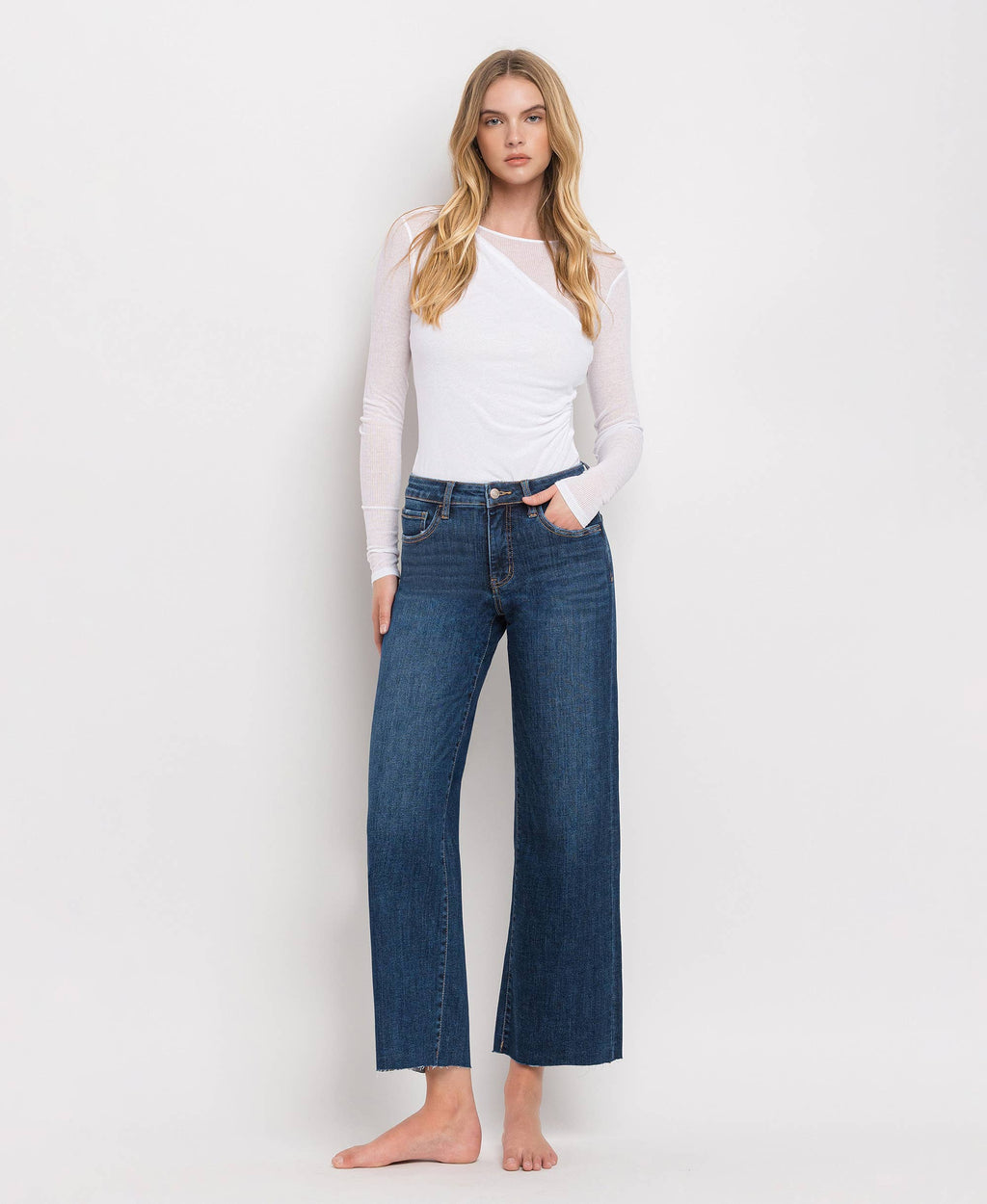 Front view of dark wash mid-rise wide leg jeans with tummy control and cropped raw hem.