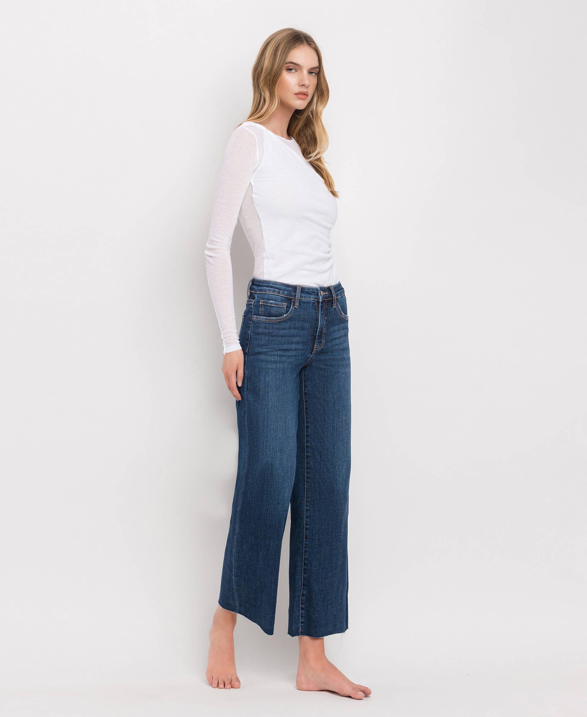 Woman wearing mid-rise dark wash wide leg jeans styled with a casual top for an effortless everyday outfit.