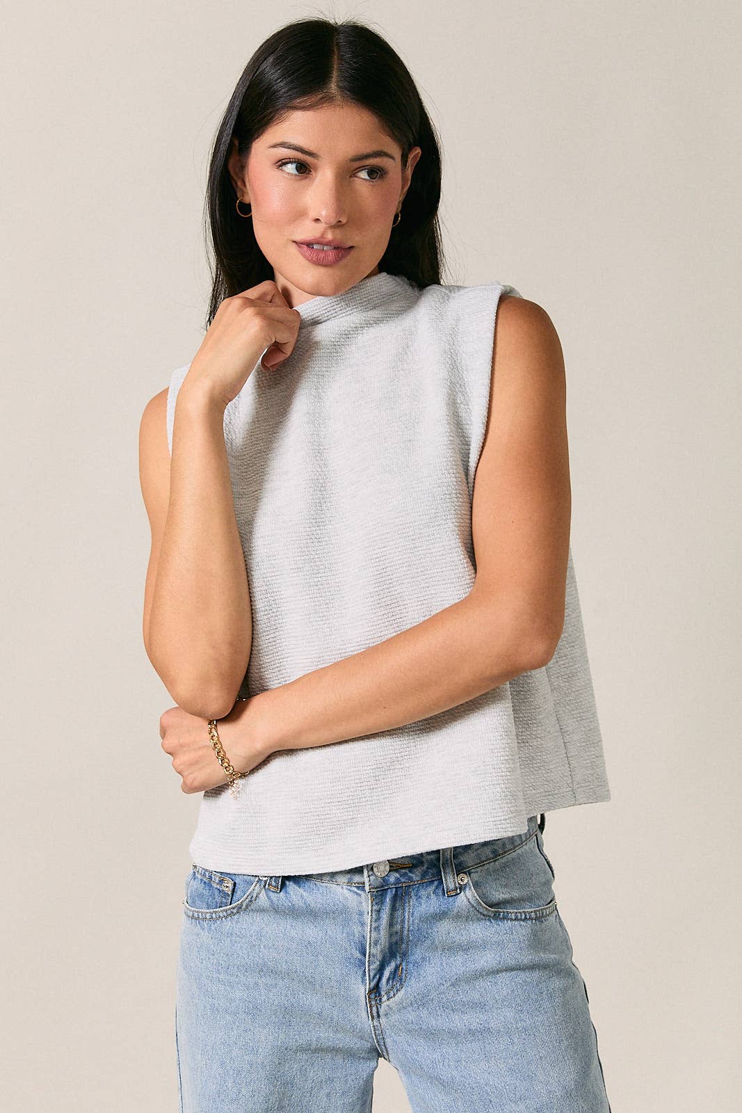 Women's light heather gray mock neck sleeveless top with folded shoulder detail and modern relaxed fit.