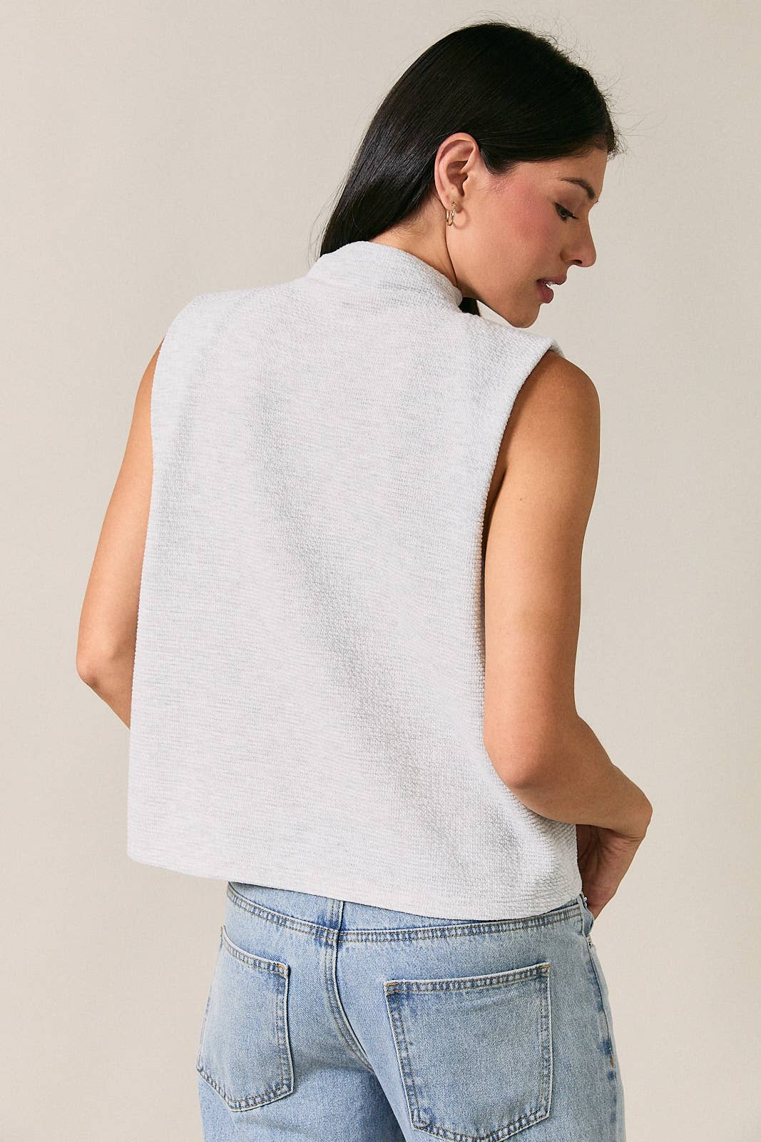 Back view of a light heather gray mock neck sleeveless top with a clean minimalist silhouette.
