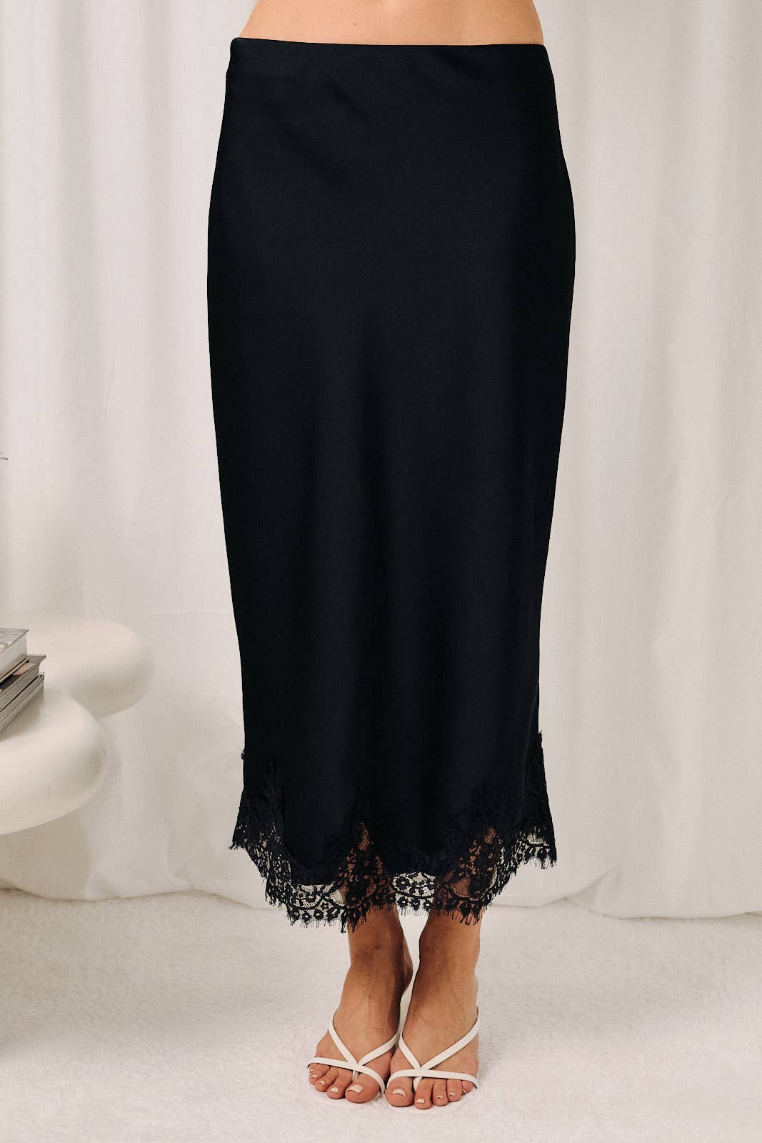 Navy lace applique satin bias midi skirt featuring a flattering draped silhouette and elegant feminine design.