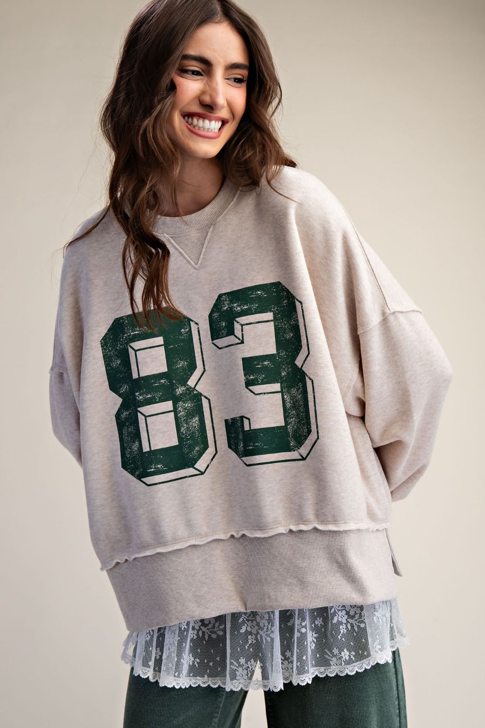 Women's oversized Number Print Washed Terry Knit Pullover featuring an 83 graphic, mineral wash finish, and distressed raw edge hem.