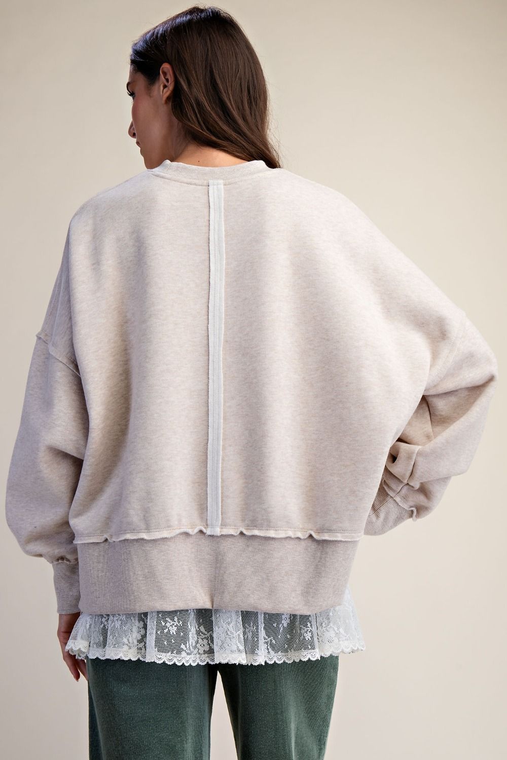 Detail view of distressed raw edge hem on oversized washed graphic pullover.