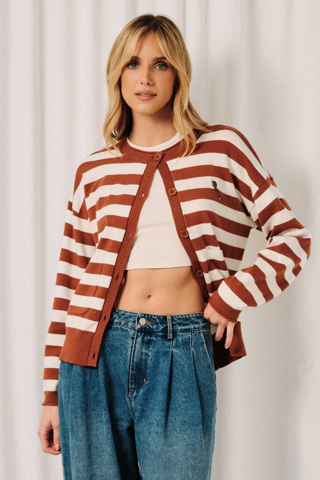 Women's rust and white stripe cardigan featuring olive embroidered detail on the front and a cozy knit design.