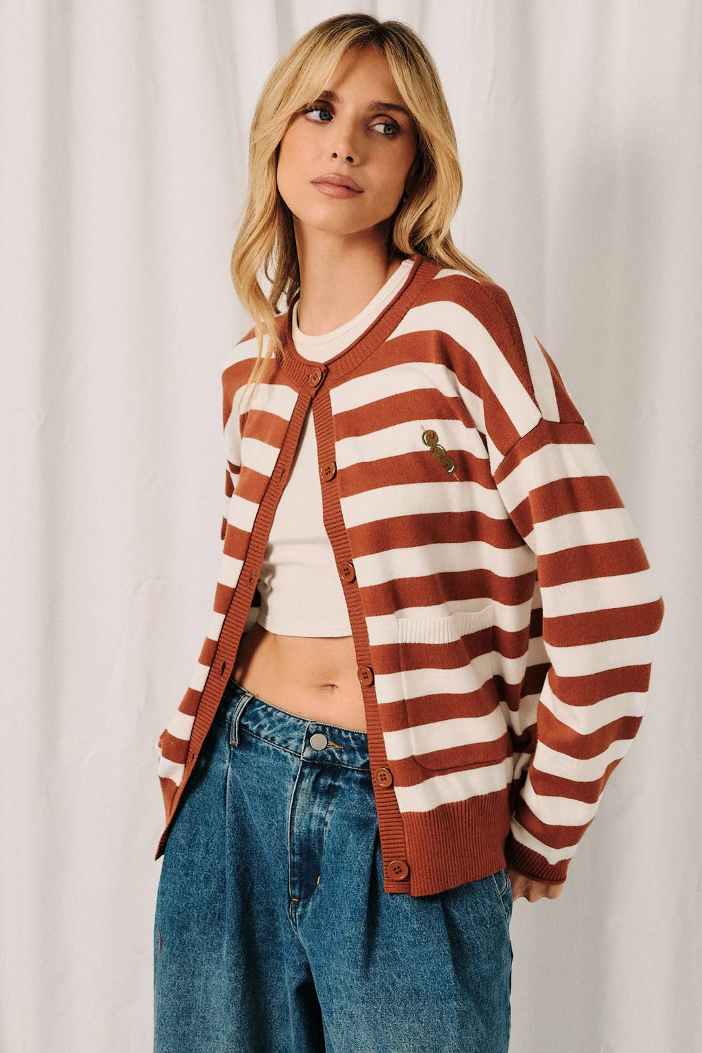 Front view of rust-white stripe cardigan with olive embroidery detail and relaxed cardigan fit.