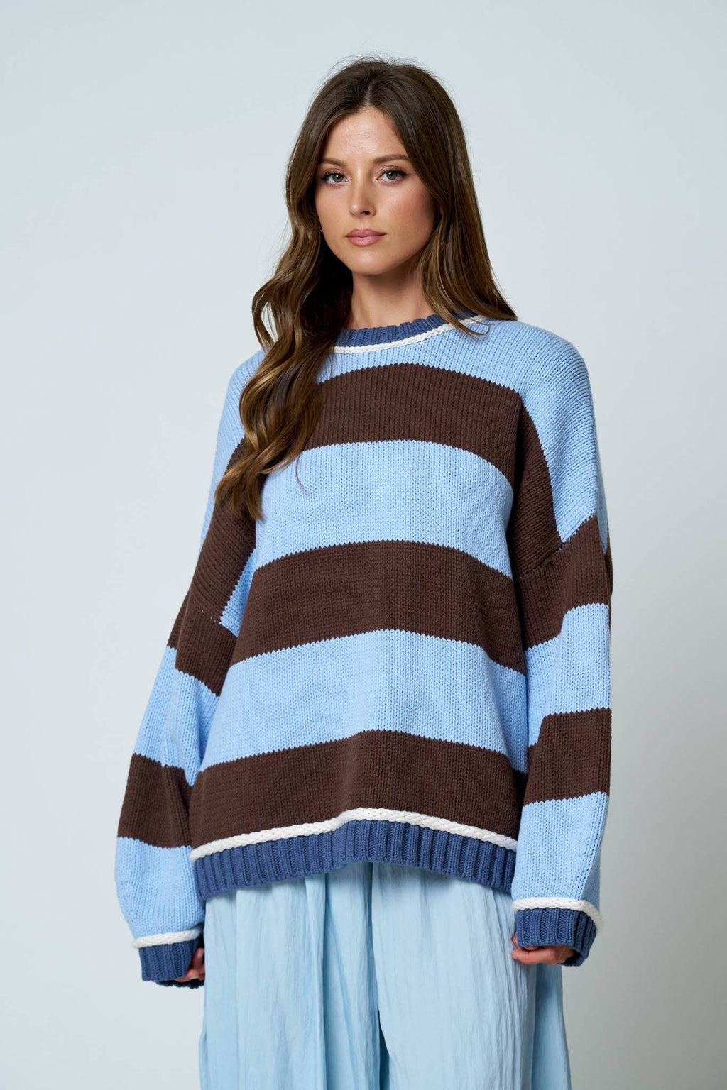 Oversized striped crew neck sweater with light blue and brown pattern.