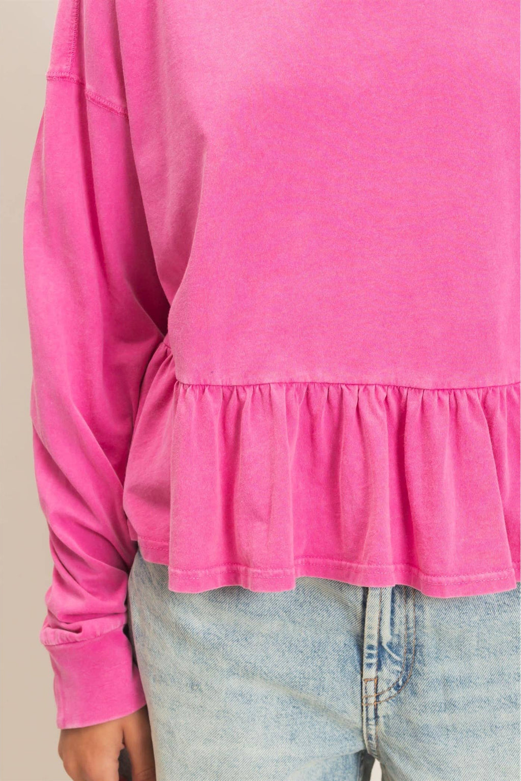Women's peplum long sleeve top with crew neckline, relaxed fit, and ruffled hem.