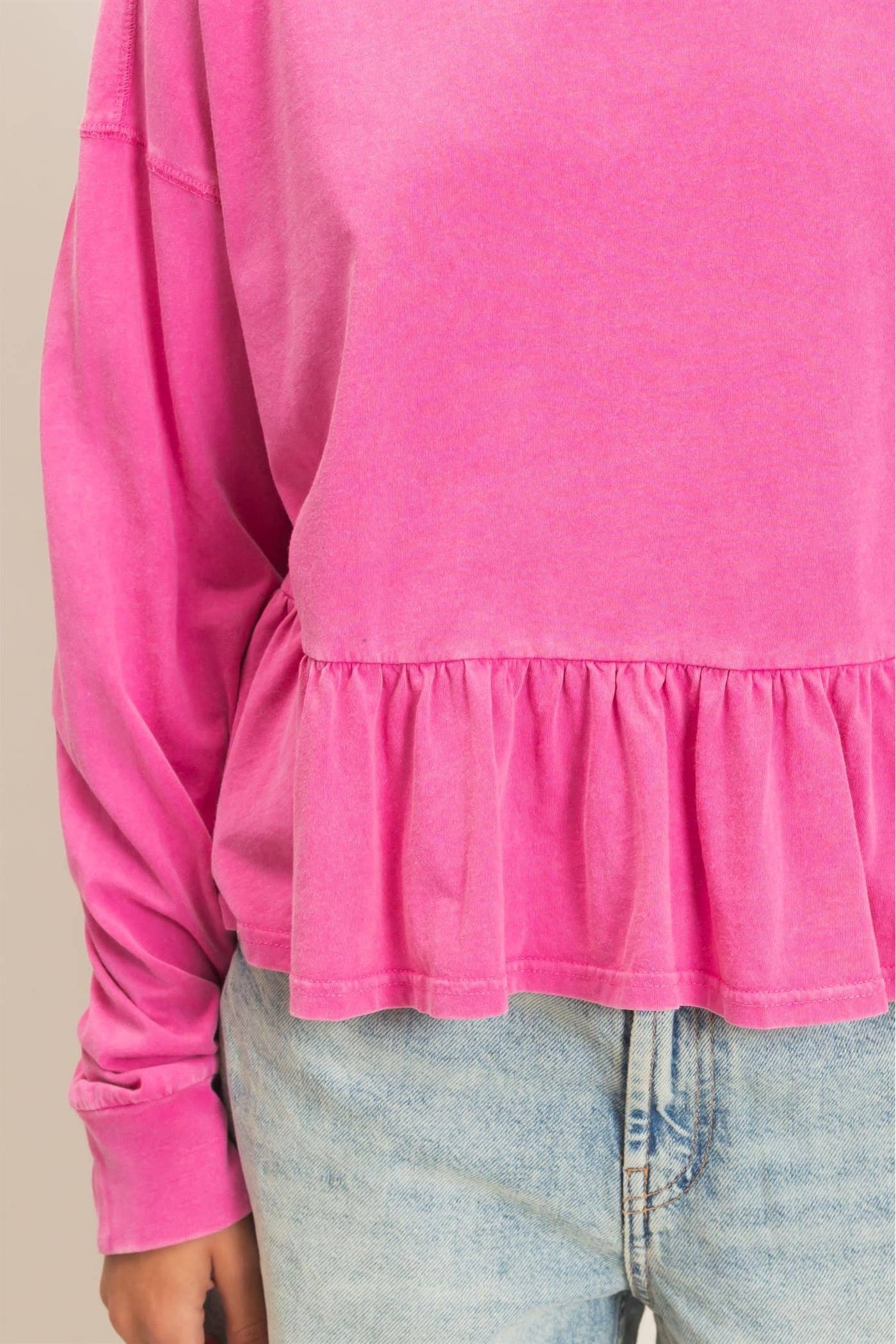 Women's peplum long sleeve top with crew neckline, relaxed fit, and ruffled hem.