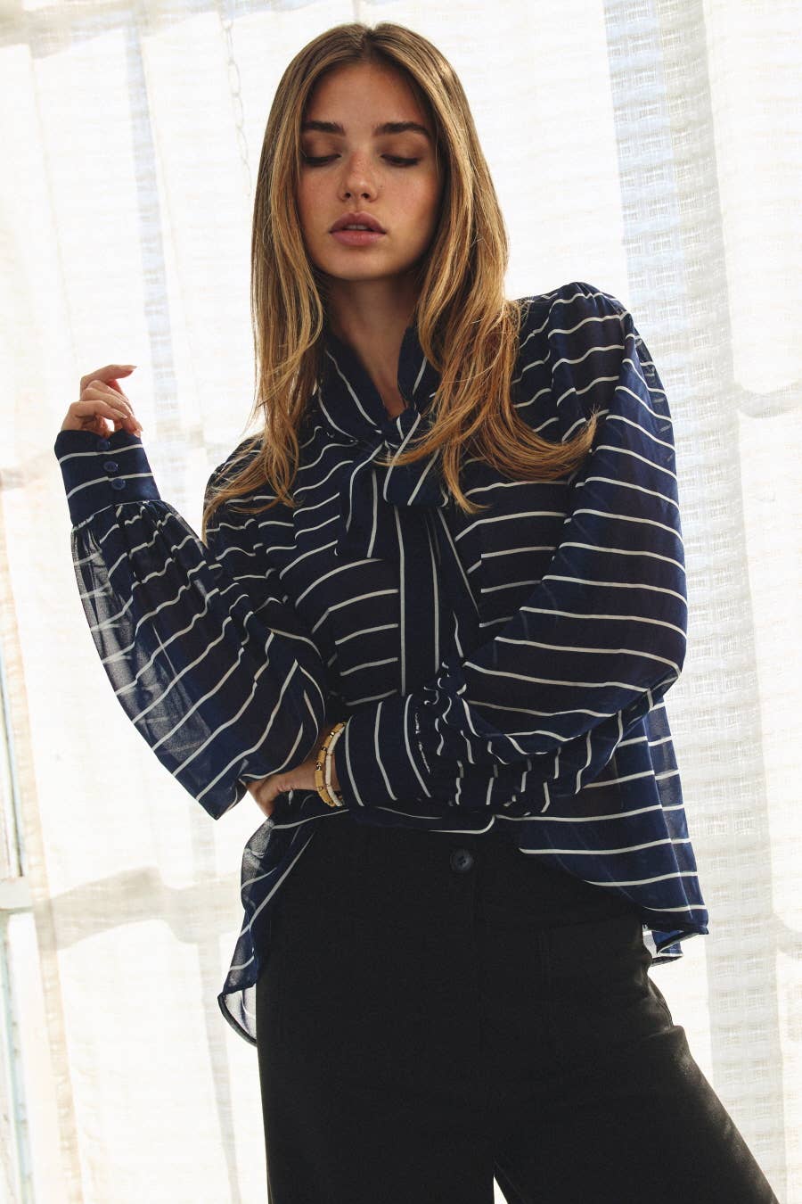 Plus size striped chiffon blouse with tie-front neckline and voluminous sleeves.