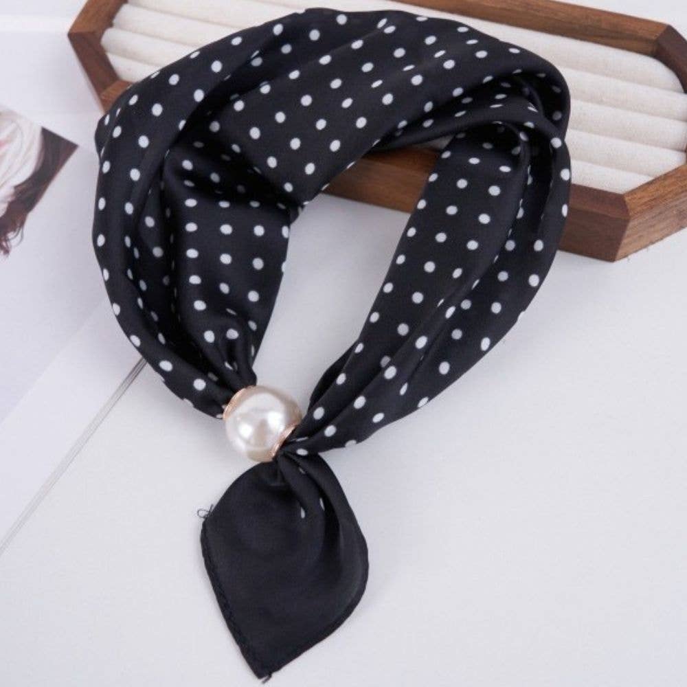 A black silk scarf with white polka dots, tied in a knot with a faux pearl accent.