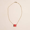 Red vintage dice charm necklace with a playful pendant design on a delicate chain.