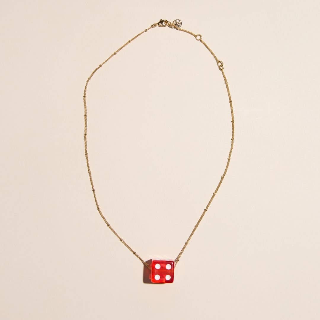 Red vintage dice charm necklace with a playful pendant design on a delicate chain.