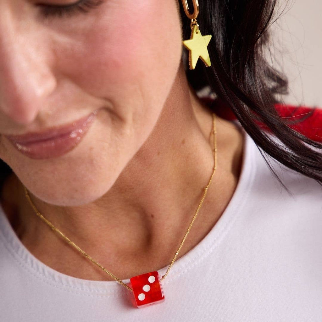 Close-up of a red vintage dice charm pendant necklace with unique statement style.