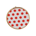 Red and white polka dot brooch with a playful vintage-inspired design.