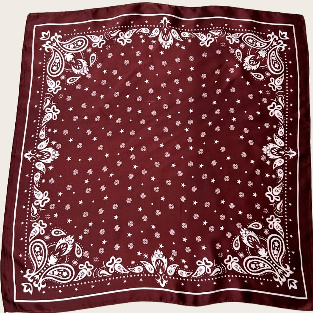 Maroon bandana with white polka dot and paisley patterns on a beige background