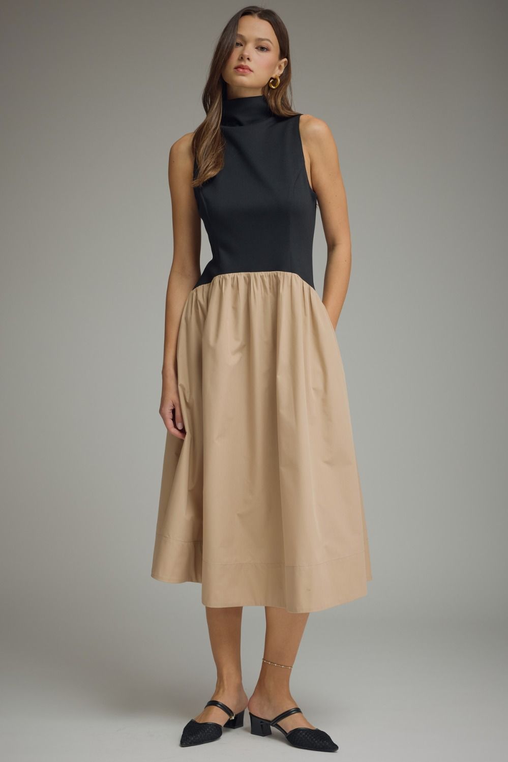 Women's sleeveless mock neck midi dress with a black knit bodice and khaki midi skirt.