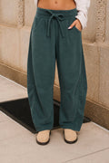 Women's washed dark green smocked waist drawstring wide leg sweatpants with relaxed fit and side pockets.
