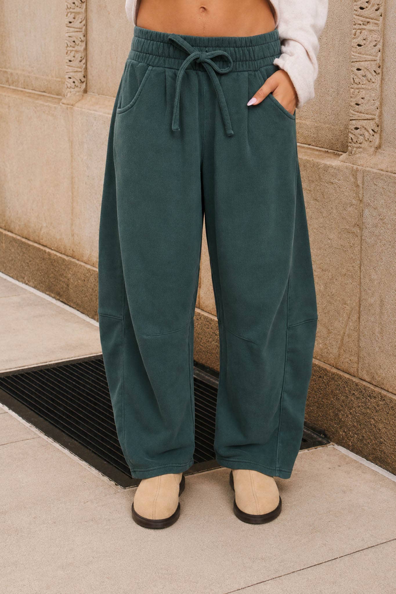 Women's washed dark green smocked waist drawstring wide leg sweatpants with relaxed fit and side pockets.