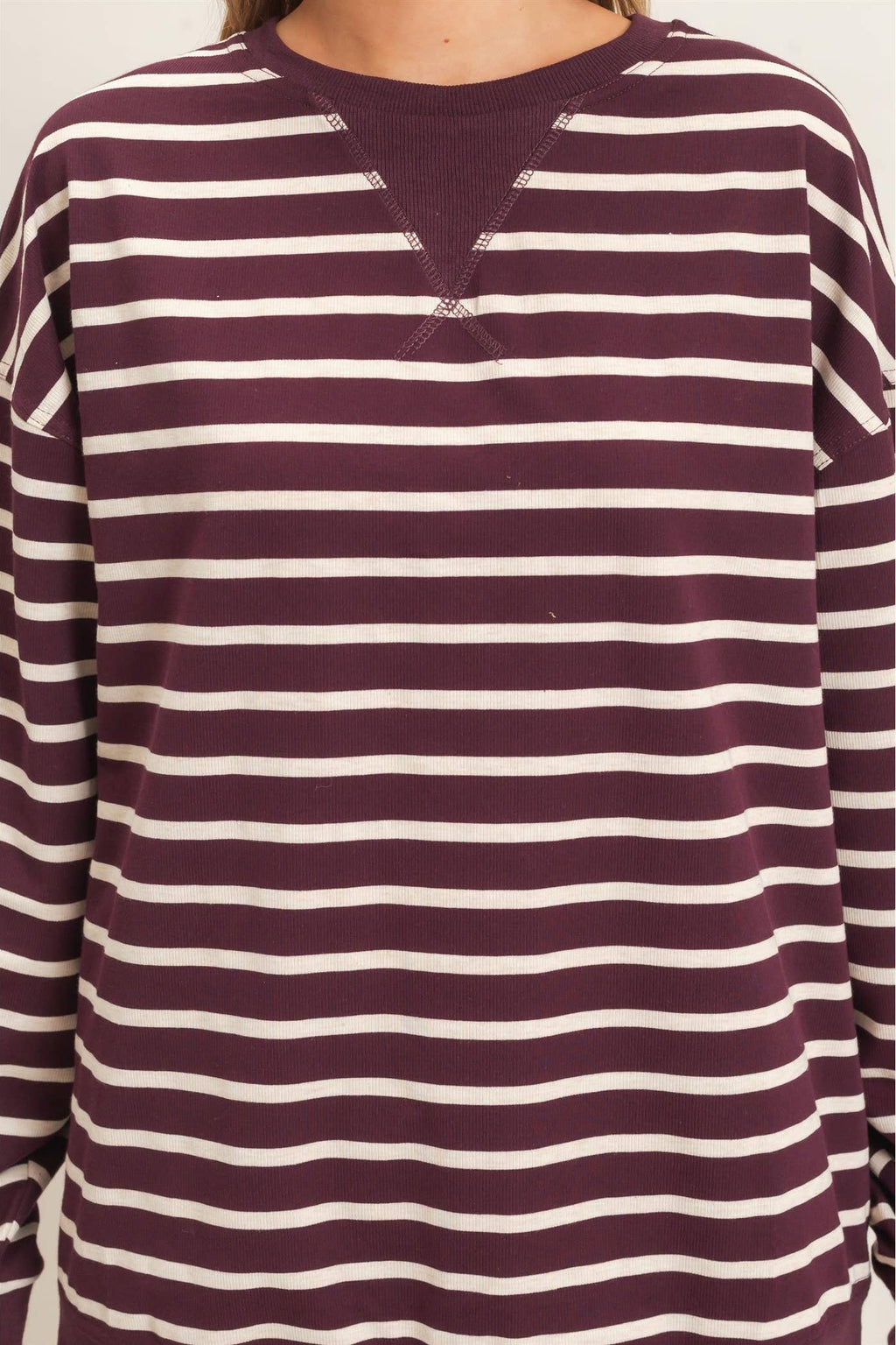 Close-up of the crew neckline on a burgundy and white striped knit pullover for women.