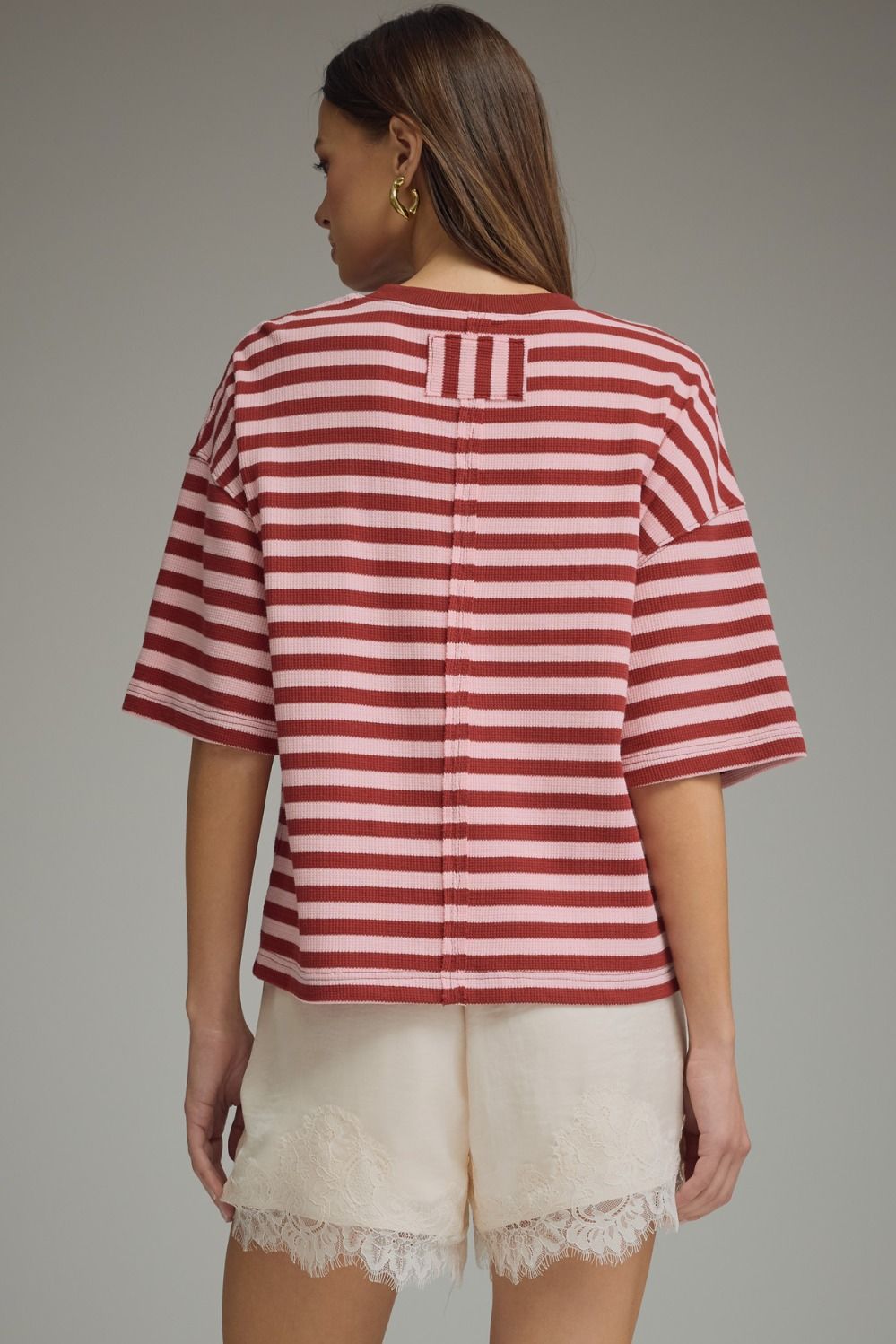 Back view of a lightweight burgundy and pink striped short sleeve top for women.