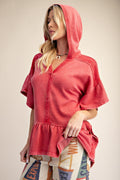 Washed Terry Ruffle Bottom Pullover with a mineral wash finish, hooded neckline, ruffled dolman sleeves, and peplum hem.