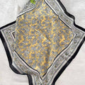 Yellow patterned fabric with black and white border on a light gray background