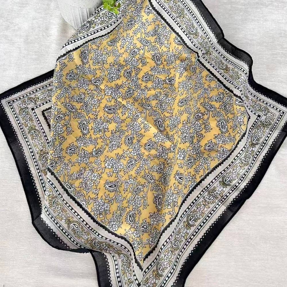 Yellow patterned fabric with black and white border on a light gray background