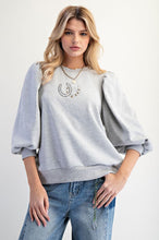 Load image into Gallery viewer, Woman wearing a gray sweatshirt with a design and blue jeans on a white background
